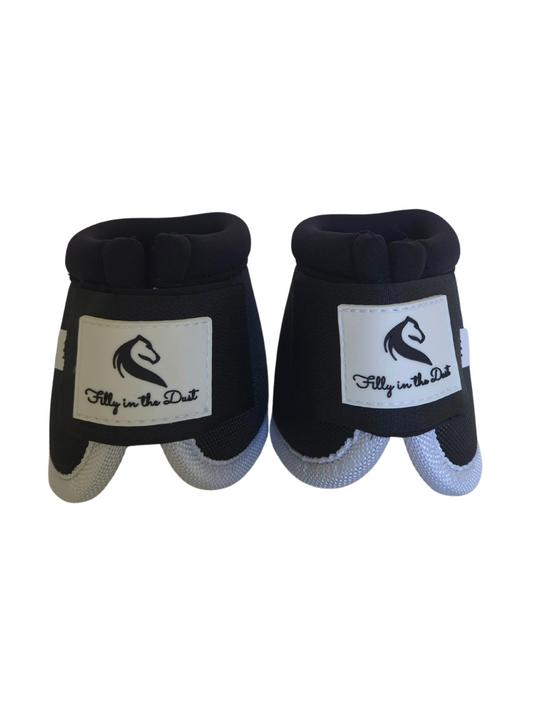 Pair of black and white protective horse bell boots with a brand logo on a white background